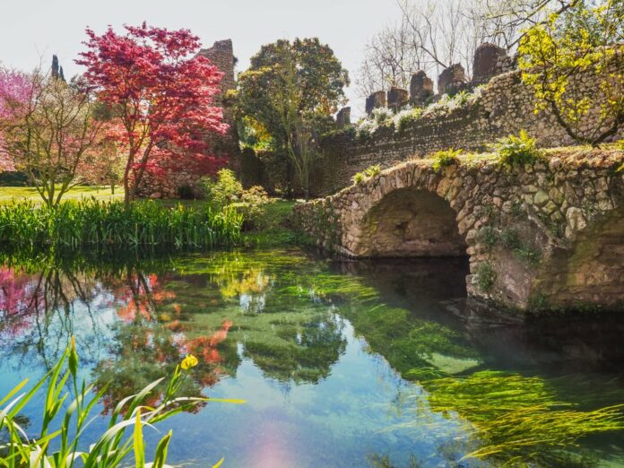 River,Ninfa,And,Ruins,Of,A,Medieval,Bridge,Are,Surrounded