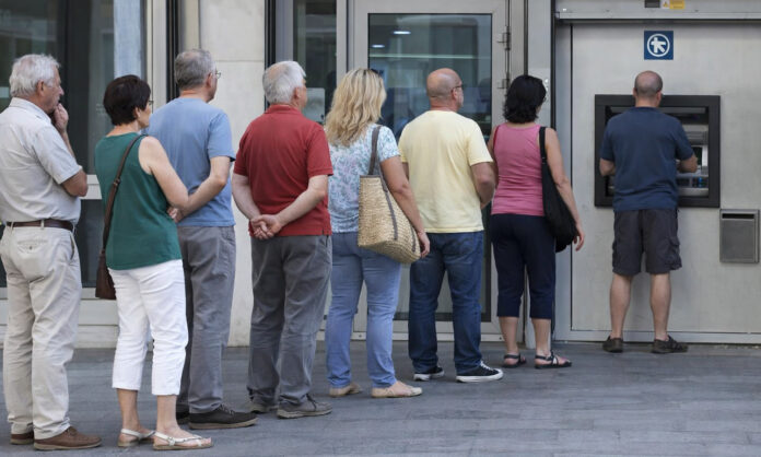 persone in fila bancomat contanti